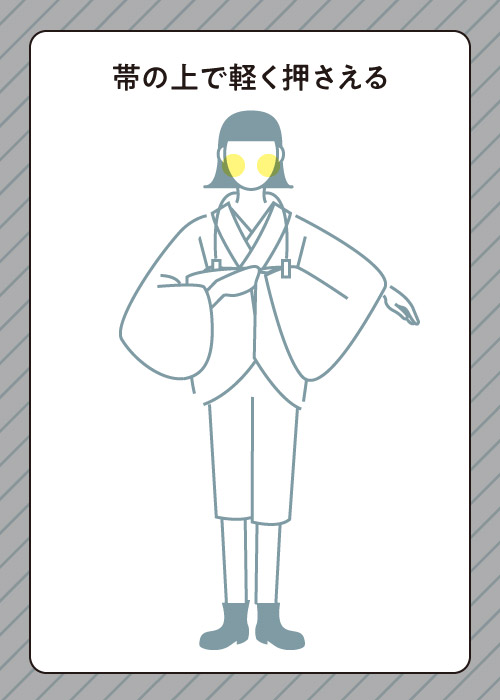 裾を帯の上で軽く押さえる